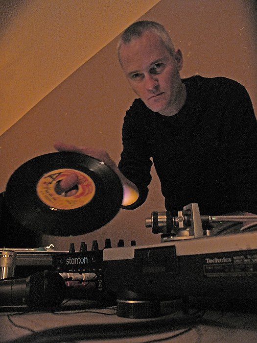 Mark Gorney cueing up a record at the turntables as DJ '66